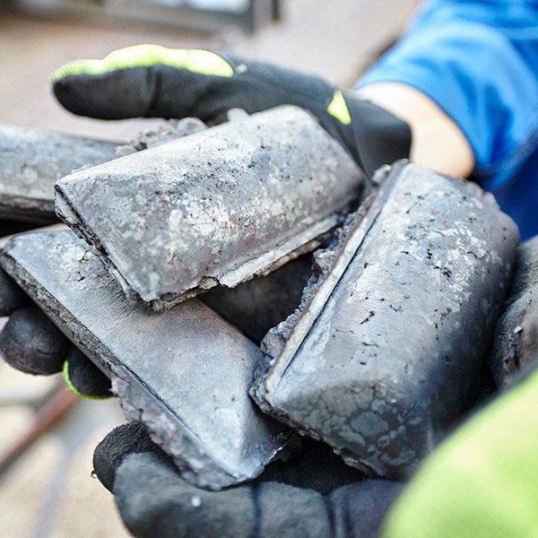 Hot briquetted iron blocks held by an industrial worker